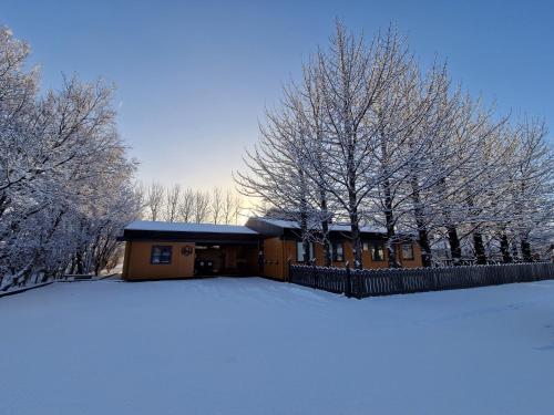 霍芬豪卡贝格旅馆的雪覆盖着栅栏和树木的房子