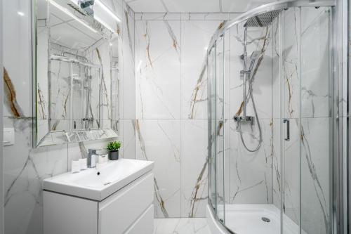 华沙Warsaw Apartments Bliska Wola的白色的浴室设有水槽和淋浴。