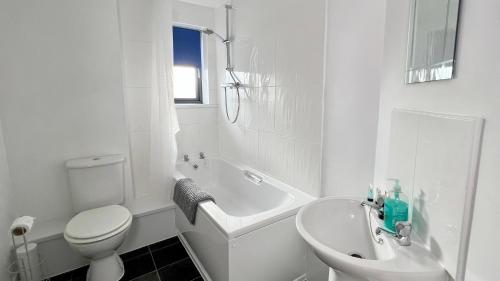斯塔福德Cross Court, Stafford by BELL Apartments的白色的浴室设有卫生间、浴缸和水槽。