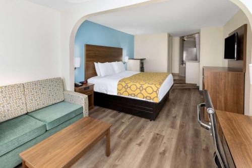 比洛克西Baymont by Wyndham Biloxi - Ocean Springs的酒店客房,配有床和沙发