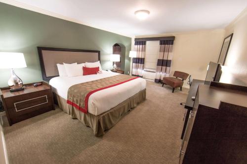 亨博尔华美达休斯敦洲际机场东酒店的酒店客房带一张大床和一把椅子