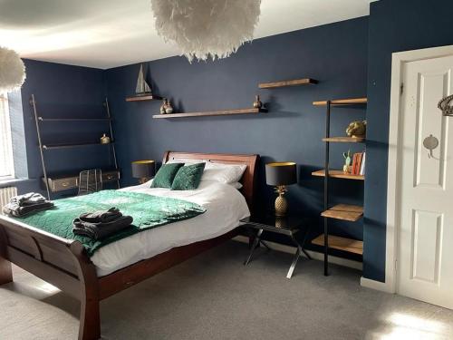 利兹The Beulah Apartments的一间拥有蓝色墙壁的卧室,配有一张床和一张桌子