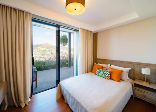 京多安Mare Deluxe Residences & Villas的一间卧室设有一张床和一个大窗户