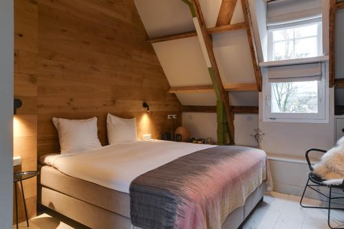 纳尔登Vesting Hotel Naarden的卧室配有一张床铺,位于带木墙的房间内
