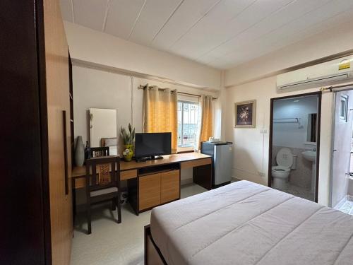 Ban Khlong Nong Yai66 Apartment的一间卧室配有一张床和一张带电脑的书桌