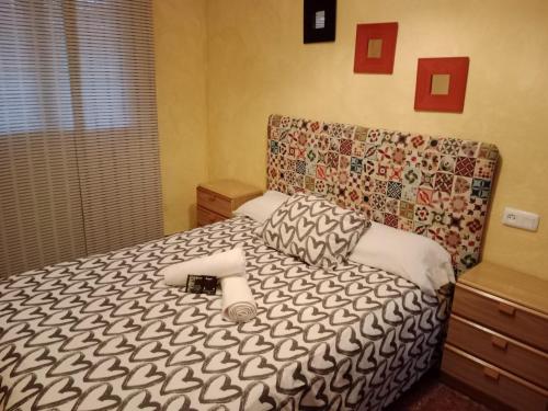 埃尔博斯克Alojamiento Rural Manantial de los Cañitos的一间卧室配有一张带黑白色棉被的床