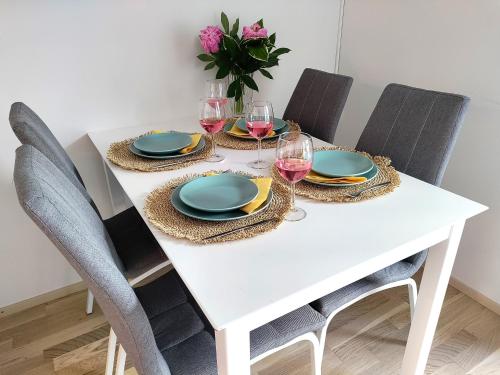 坦佩雷Fully Equipped New Apartment With Free Parking的白色的餐桌,配有盘子和酒杯