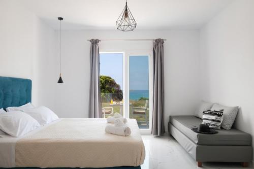 阿里拉斯Diamond Arillas Luxury Apartments的一间卧室配有一张床、一张沙发和一个窗口