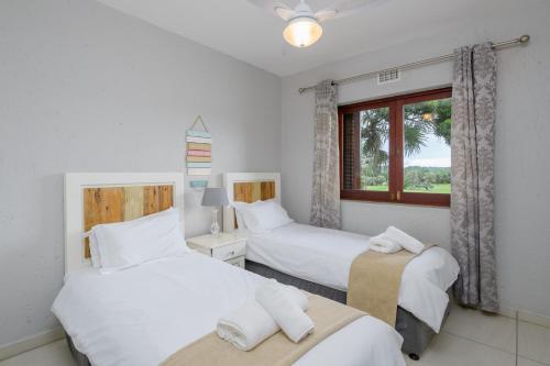 绍斯布鲁姆San Lameer Villa 3708 - 4 Bedroom Classic - 8 pax - San Lameer Rental Agency的一间卧室设有两张床和窗户。