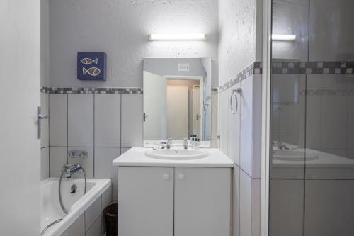 绍斯布鲁姆San Lameer Villa 3708 - 4 Bedroom Classic - 8 pax - San Lameer Rental Agency的一间带水槽、浴缸和镜子的浴室