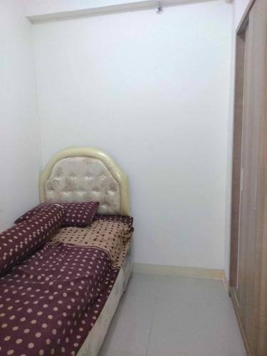 雅加达Green Pramuka City的一张小床,位于客房的角落