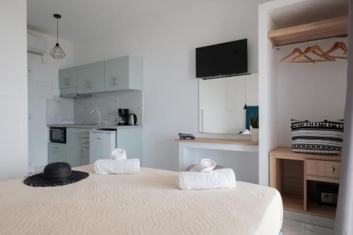 阿里拉斯Diamond Arillas Luxury Apartments的白色客房,配有带毛巾的床