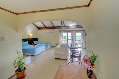 霍尼亚拉Honiara Hotel的配有一张床和一张桌子及椅子的房间