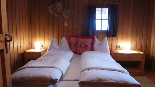 安泰塞尔瓦·迪·梅佐木屋维尔德高度假屋的两张床铺,房间有两个灯