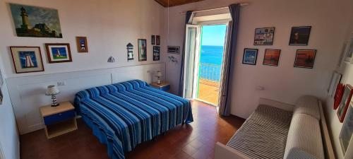 马西亚娜马里纳Villa Le Sprizze a bordo del mare - Goelba的一间卧室设有一张床,一扇通往大海的门