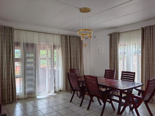 马盖特Msongi Guest House的一间带桌椅和窗户的用餐室