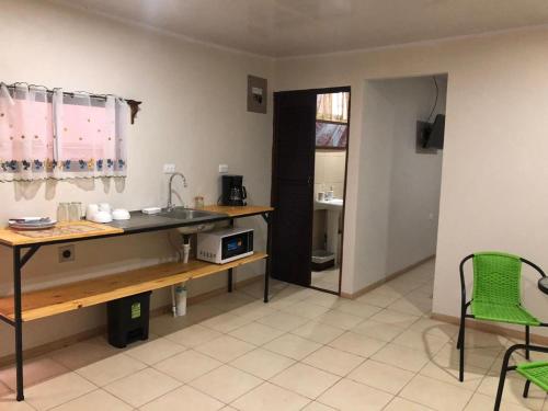 Santiago EsteRivera Family Apartments的厨房配有水槽和桌椅