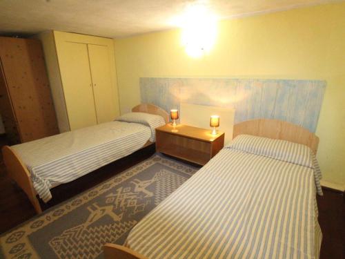 坎尼吉翁4-room apartment Tanca Manna, only 300 meters from the beach的一间设有两张床和一张带两个蜡烛的桌子的房间