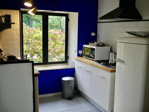 普卢阿Nature, Mer, Golf & Decouvertes...的厨房配有白色冰箱和窗户。