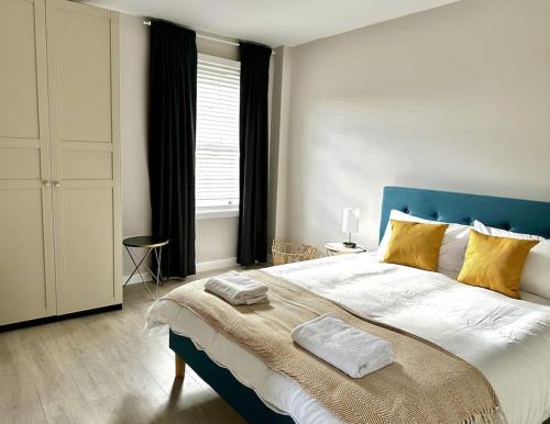 伦敦Sienna's 2 - bedroom apartment, London, N1.的一间卧室配有一张大床和蓝色床头板