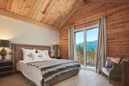 圣埃蒂安德蒂内埃Luxueux chalet avec terrasse Auron的一间卧室设有一张床和一个大窗户