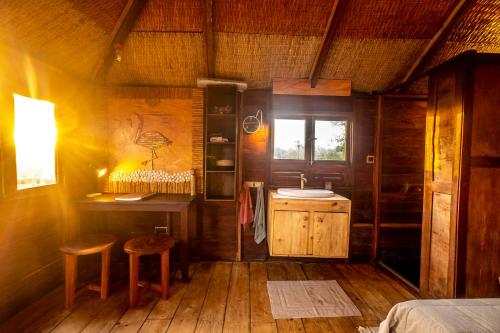 SanyangMansa Musso Treehouse Resort的配有床、桌子和凳子的房间