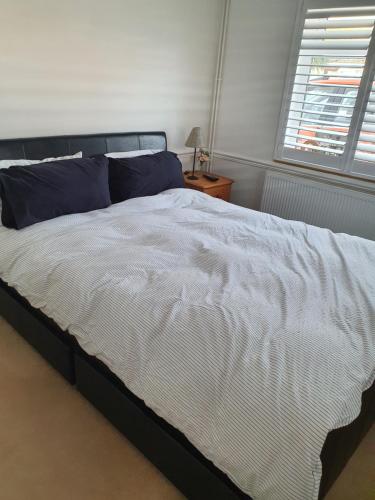 Waldingfield30 Heath Estate的卧室配有带蓝色枕头的大型白色床