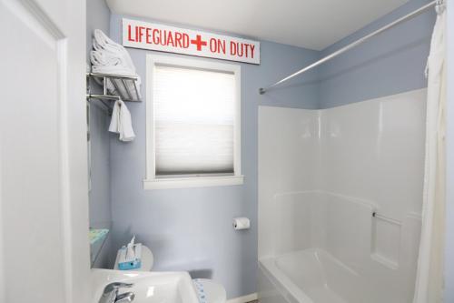 五月岬郡南风汽车旅馆的浴室设有白色卫生间,墙上有标志