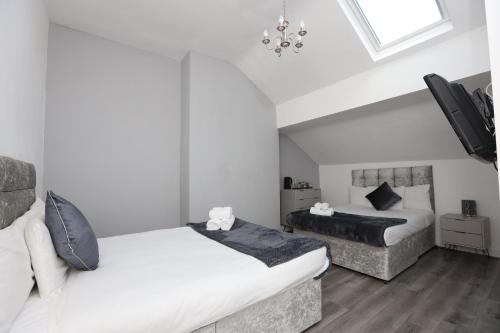 利物浦Hotel Anfield的一间卧室配有两张床和吊灯。