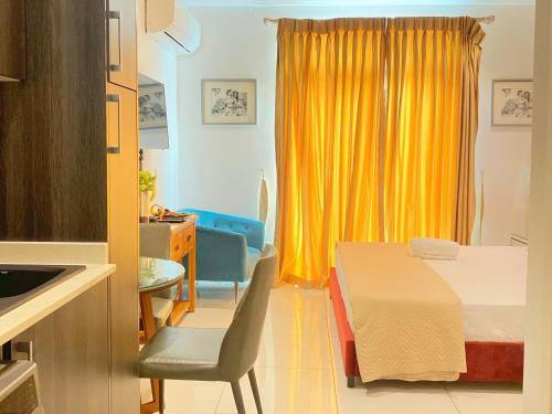 阿克拉Splendid Apartments - Embassy Gardens的一间设有床和桌子的房间,以及黄色窗帘
