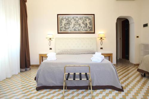 特拉帕尼阿尔贝戈鲁索酒店的一间卧室配有一张床,上面有两条毛巾