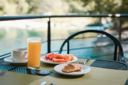 帕伦克那图屯帕伦克酒店的一张桌子,上面放着两盘食物和一杯橙汁