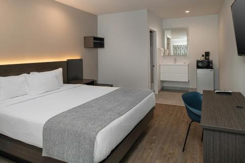 巴斯托66号线汽车旅馆的酒店客房设有一张大床和一张书桌。