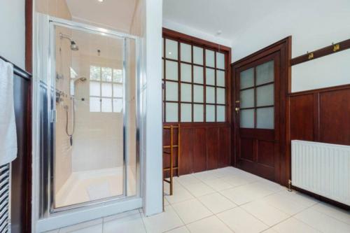 斯特灵Newholme House的一间带步入式淋浴间和玻璃门的浴室