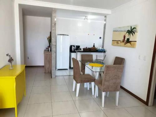 瓜拉派瑞Apartamento em Guarapari的厨房配有桌椅和冰箱。