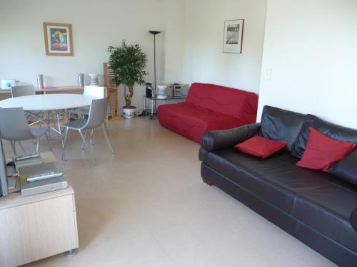 安格雷Appartement Ranavalo Pays Basque的客厅配有红色的沙发和桌子