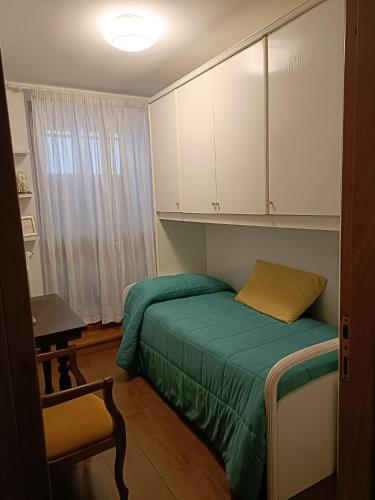 法诺Casa Elisabetta的一间小卧室,配有一张绿色的床和白色的橱柜