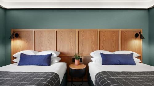 霍兰Haworth Hotel at Hope College的两张带蓝色和白色枕头的床