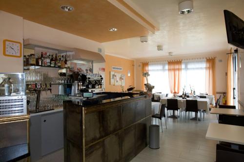 托莱港Hotel Ristorante Klaus的一间带酒吧的餐厅和一间用餐室