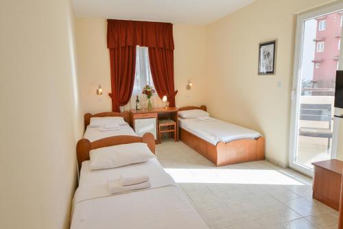 布德瓦坡多斯特罗格酒店的客房设有三张床、一张书桌和一个窗户。