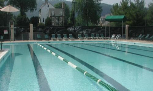 Haymarket永绿宾馆的一座蓝色海水和椅子的大型游泳池