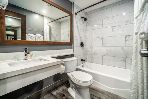 圣路易斯-奥比斯保Hotel Calle Joaquin - San Luis Obispo的浴室配有卫生间、盥洗盆和浴缸。