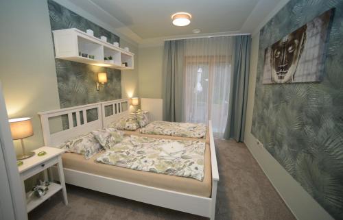 Győrújbarát科维纳别墅的一间卧室设有一张大床和一个窗户。