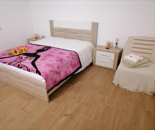 米尔芳提斯城Lar Dos Guerreiros的一间卧室配有一张大床和一张带床头柜的桌子