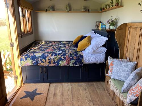 兰波特Marsh Farm Glamping Shepherd Hut的一间卧室配有带枕头的床