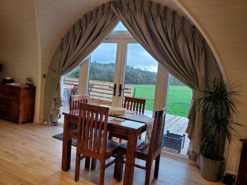Charlton MusgroveRiding Gate Lodge的一间带桌椅和大窗户的用餐室