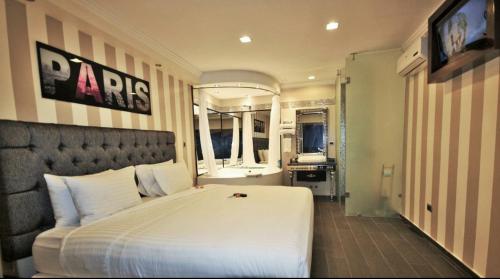 瓜亚基尔Cedros Inn Boutique Hotel的一间带白色大床的卧室和一间浴室