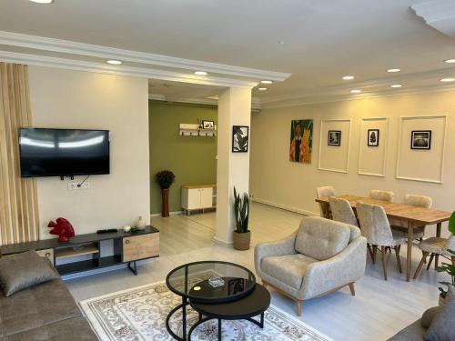 伊斯坦布尔Sisli Centre Lux的客厅配有桌椅和电视。
