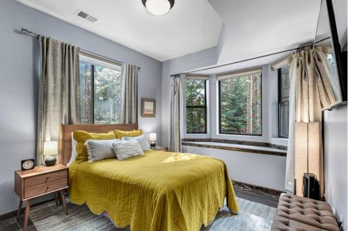 布雷肯里奇Luxury Modern Townhome steps to ski lifts and downtown with Nature at your patio的一间卧室配有一张带黄色床罩和窗户的床。