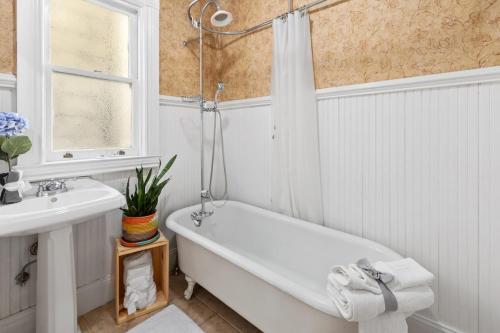旧金山Gorgeous Victorian Flat的白色的浴室设有浴缸和水槽。